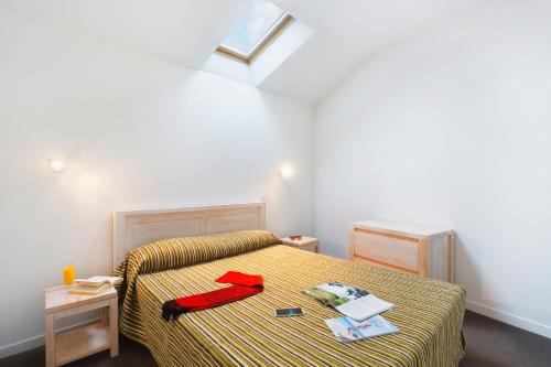 レ・サ​​ーブル・ドロンヌにあるRésidence Néméa Les Grands Rochersのベッドルーム1室(赤いアイテムが付いたベッド1台付)