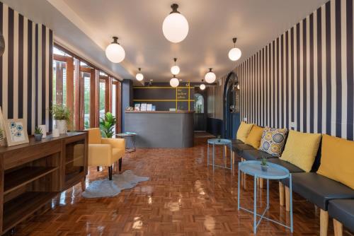 a lobby with blue and yellow furniture and a counter at The Mellow Pillow Hotel @ Chiang Mai Gate in Chiang Mai