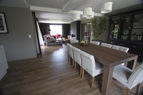 comedor y sala de estar con mesa de madera y sillas en Villa Brion**** en Wenduine