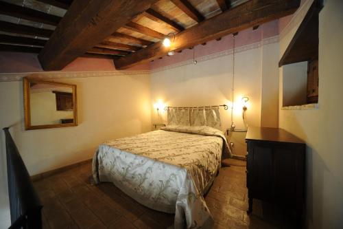 a bedroom with a bed and a dresser and a mirror at Antico Casale Urbani in Scheggino