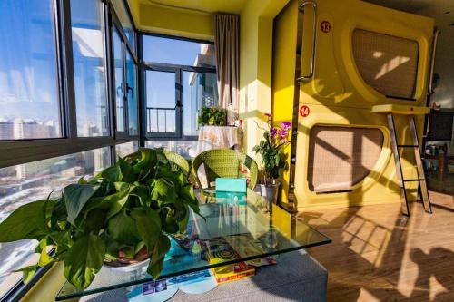 a living room with a glass table with a plant at Wuwei Qiyou Space Capsule Hostel in Wuwei