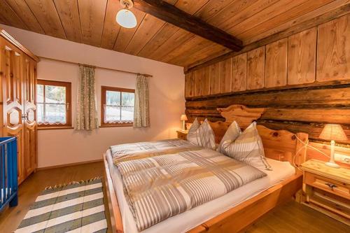 ein Schlafzimmer mit einem großen Bett in einem Zimmer mit Holzwänden in der Unterkunft Bauernhütte Niedermaisgut in Eben im Pongau
