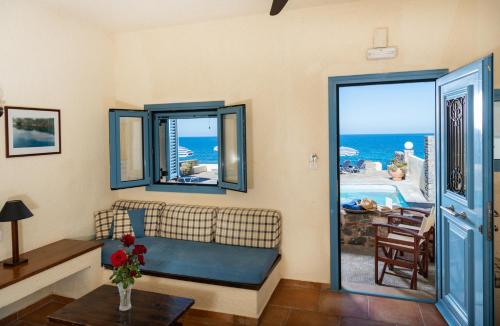 a living room with a couch and a view of the ocean at Porto Sisi Hotel Apartments in Sisi