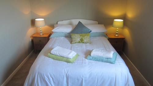 a large white bed with pillows on top of it at 8B Calbost in Calbost