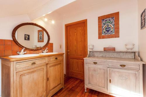 uma casa de banho com um lavatório e um espelho em La maison du lac em Cul-des-Sarts
