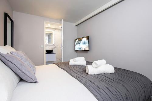 a bedroom with a large white bed with two towels at Original twin Studio Delft City Central Station 30B in Delft