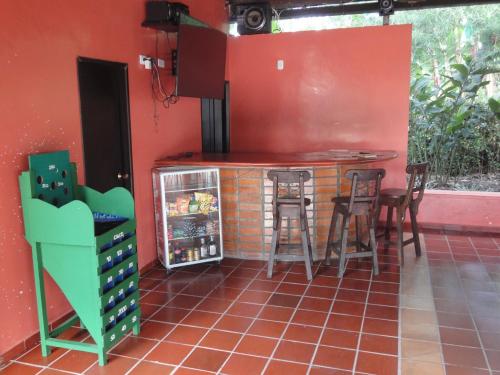 a kitchen with a counter and stools in a room at Villa Thiago Finca in Armenia