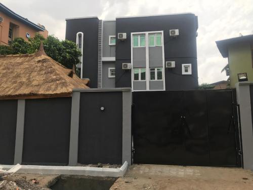 a house with a black gate and a building at Choice Suites II in Ikeja