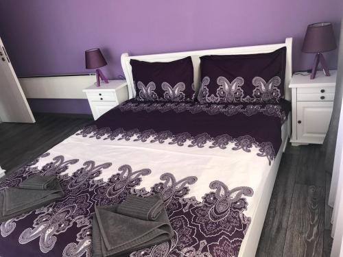 バンスコにあるPredela 1 Bansko Apartmentの紫色のベッドルーム(黒と白のベッドカバー付)