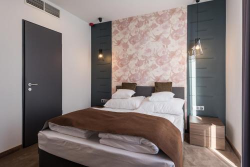 a bedroom with a large bed and a pink wall at Várda Sport Hotel in Kisvárda