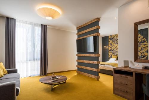a hotel room with a bed and a couch at Várda Sport Hotel in Kisvárda