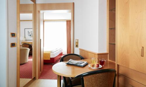 a hotel room with a table and a bed at Living Hotel Großer Kurfürst in Berlin