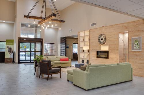 a lobby with couches and a clock on a wall at Country Inn & Suites by Radisson, Harlingen, TX in Harlingen