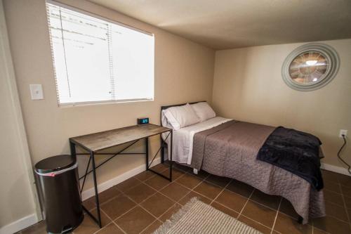 a bedroom with a bed and a table and a window at Hays #B Near Downtown Guest Studio in San Antonio