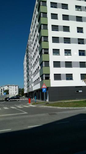 a tall white building on the side of a street at Apartman Nadja Arena Zagreb in Zagreb