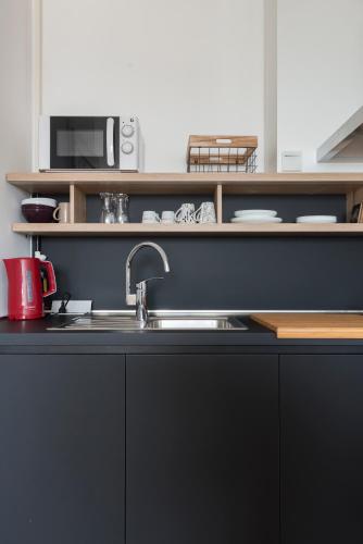 a kitchen with a sink and a microwave at Apartman Nadja Arena Zagreb in Zagreb