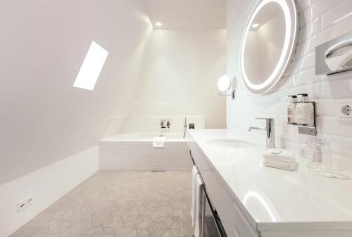 a white bathroom with a sink and a mirror at Apótek Hotel Reykjavík by Keahotels in Reykjavík