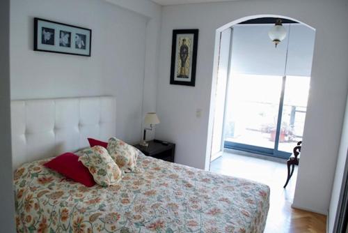 a bedroom with a bed with red pillows on it at Puerto Madero Apart in Buenos Aires