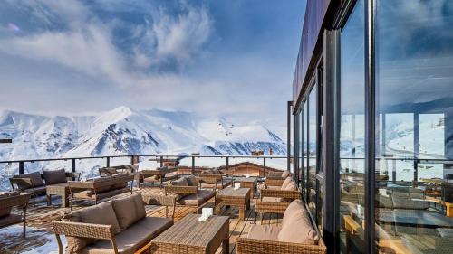 balcone con sedie, tavoli e vista sulle montagne di Gudauri Loft (Mgzavrebi) a Gudauri
