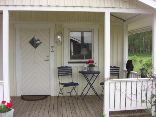 ein Haus mit einer Veranda mit Stühlen und einer Tür in der Unterkunft Ängshyddan B&B in Yngsjö