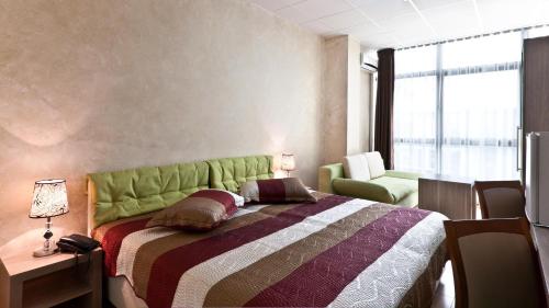 a bedroom with a bed with a green headboard at Hotel Green Center Gili in Gostivar