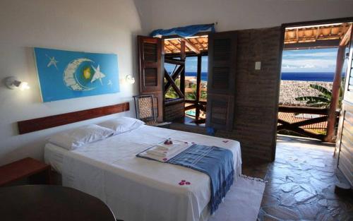 a bedroom with a bed with a view of the ocean at Pousada Lua Estrela in Canoa Quebrada