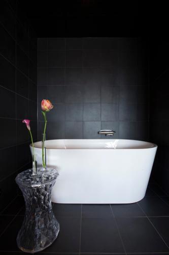 a white bath tub with a vase with a flower in it at Radisson Blu Riverside Hotel in Gothenburg