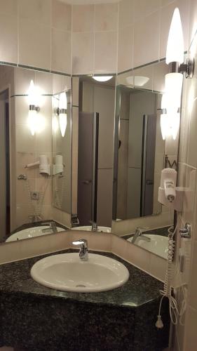 a bathroom with a sink and a large mirror at Ferienwohnung Wasserblick mit Balkon in Dewichow