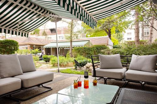 a patio with two couches and a glass table at Mercure Paris Ouest Saint Germain in Saint-Germain-en-Laye