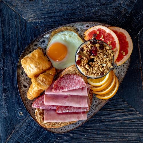 a plate of breakfast food with eggs ham and toast at Litli Geysir Hotel in Haukadalur