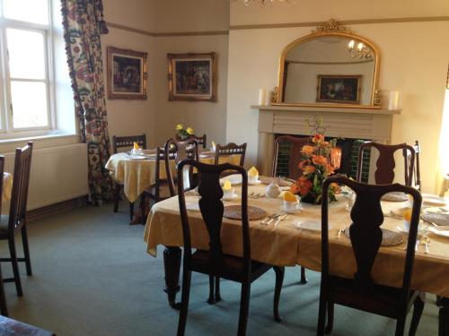 a dining room with a table and a mirror at Pickmere Country House in Pickmere