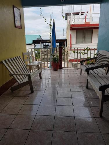 a patio with two benches and an umbrella at Hotel Posada Tayazal in Flores