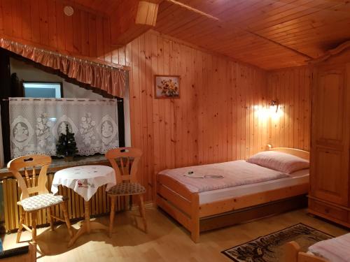 シュチルクにあるEDEN Szczyrkのベッドとテーブルと椅子のある寝室