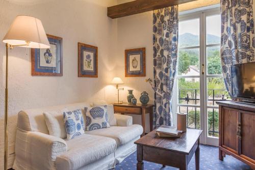 a living room with a couch and a tv at La Meridiana ReIais & Chateaux in Garlenda