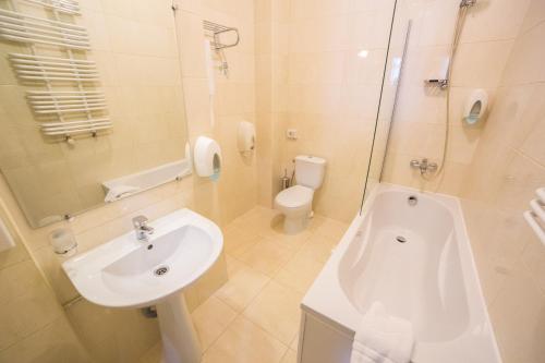 a white bathroom with a sink and a toilet at Optima Dworzec Lviv in Lviv