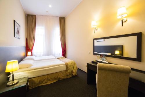 リヴィウにあるOptima Dworzec Lvivのベッドと大きな鏡が備わるホテルルームです。