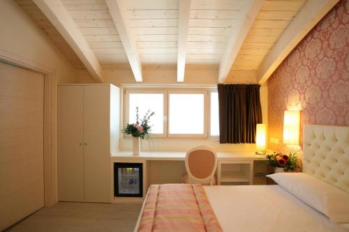 a bedroom with a bed and a desk and a window at Nuova Opera Rooms in Verona