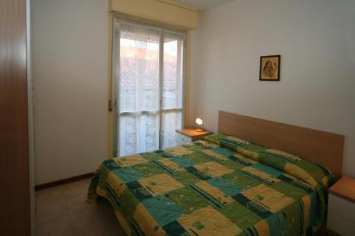 una camera con letto e finestra di Casa Al Mare a Lignano Sabbiadoro