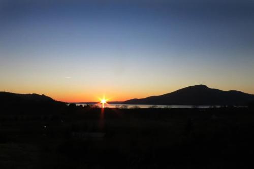 a sunset over the water with mountains in the background at Skye View in Glenelg
