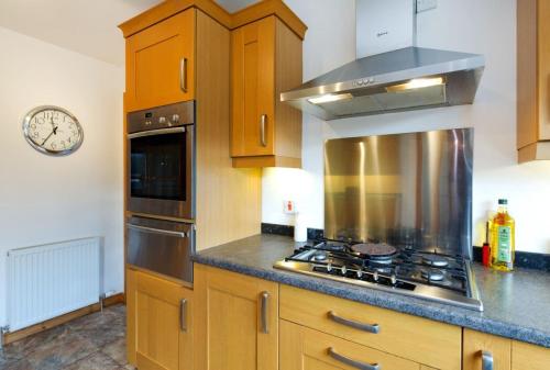 a kitchen with wooden cabinets and a stove top oven at Skye View in Glenelg