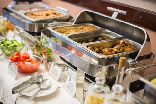 a buffet with several trays of food on a table at Optima Collection Medievale Lviv in Lviv