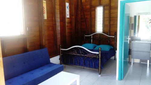 a bedroom with a bed with blue pillows on it at LESTEPHANIA in Le Moule