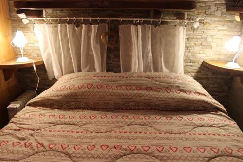 a bed in a room with two lamps on two tables at Fiocco di Neve in Montjovet