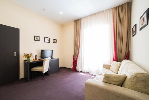 a living room with a couch and a desk and a television at Optima Dworzec Lviv in Lviv