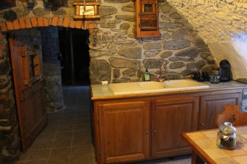 a kitchen with a sink and a stone wall at Fiocco di Neve in Montjovet