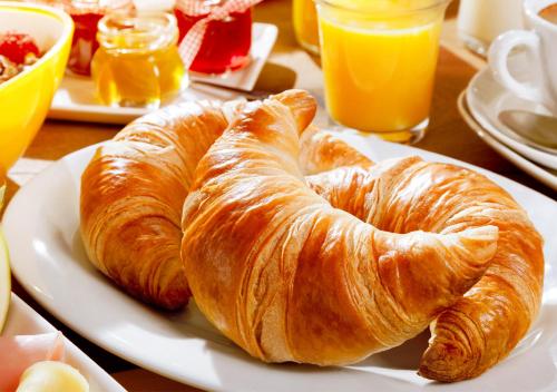 dos croissants en un plato blanco en una mesa en Penthouse Kaprun by Kaprun Rentals, en Kaprun