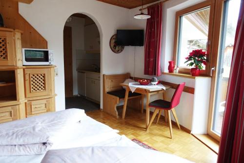 a bedroom with a bed and a table and a kitchen at Apart Stotter in Kappl