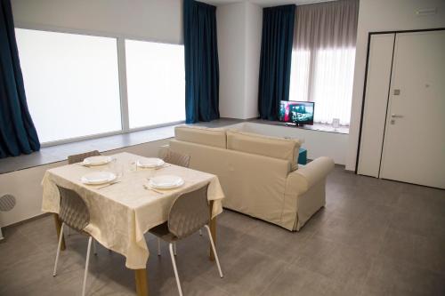 sala de estar con mesa y sofá en Rivabella Suite Apartments, en Rímini