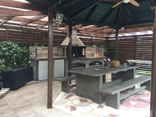 - un barbecue extérieur avec une table de pique-nique et un parasol dans l'établissement Litsa Haus Estate Residences & Suites - Adults Only & Kids 10 Plus-, à Asprovalta