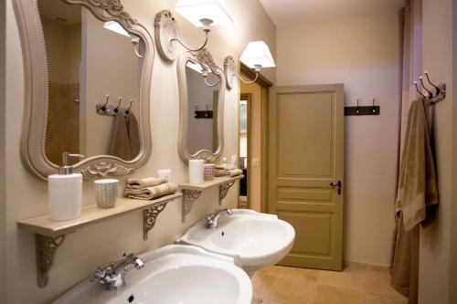 コンドンにあるLes Hauts de Condom Appartements Climatisesのバスルーム(洗面台、鏡2つ、トイレ付)
